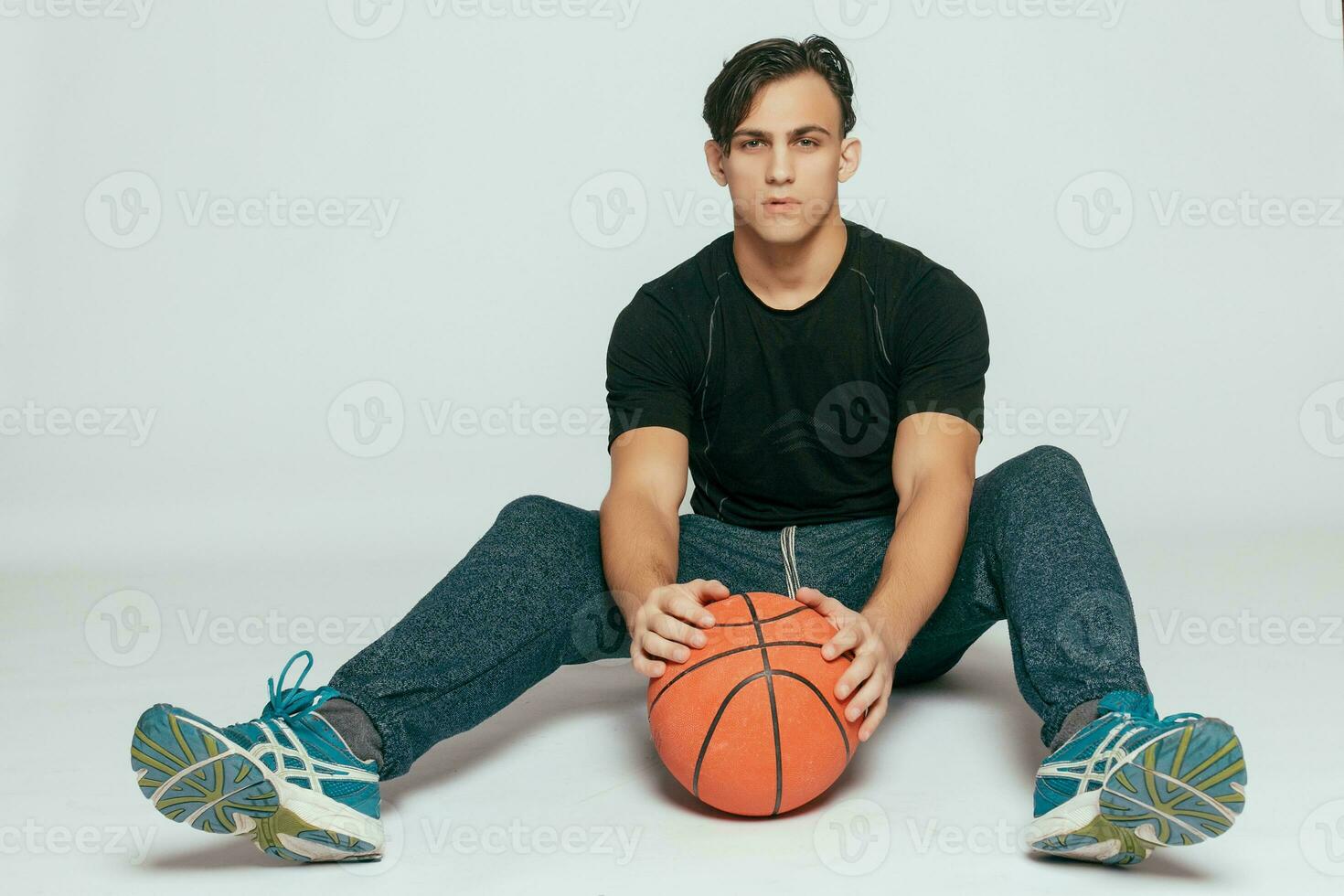 Handsome young smiling man carrying a basketball ball photo