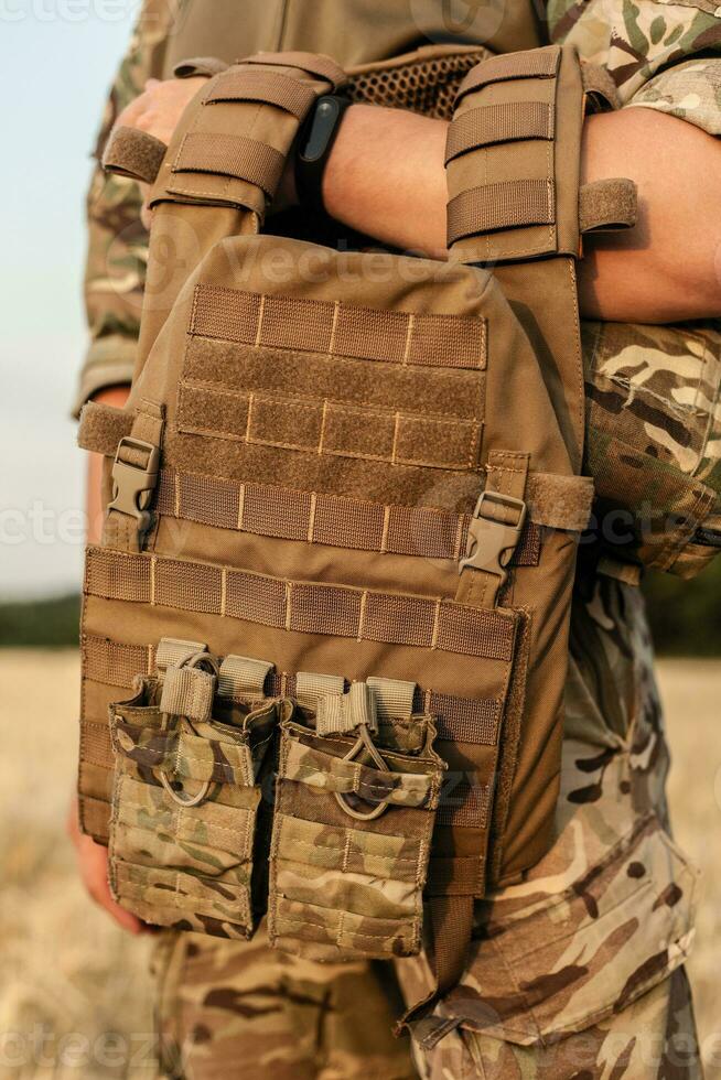 Soldier man standing against a field photo