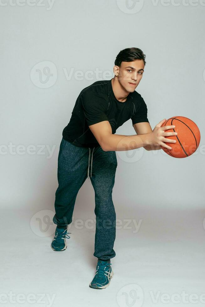 Handsome young smiling man carrying a basketball ball photo