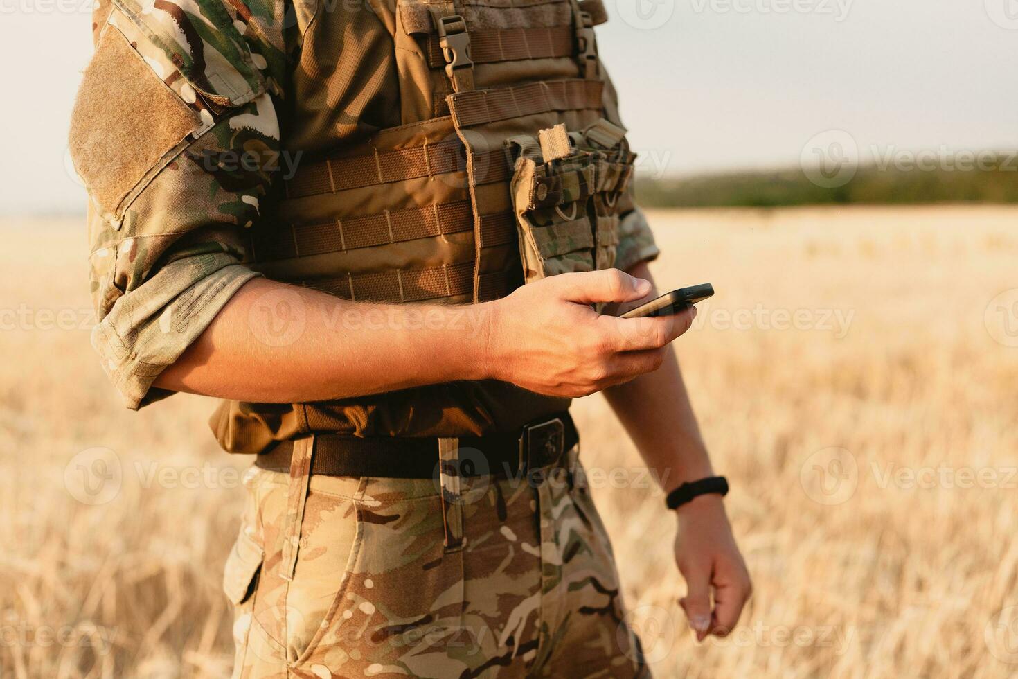 Mid section of military soldier using mobile phone photo