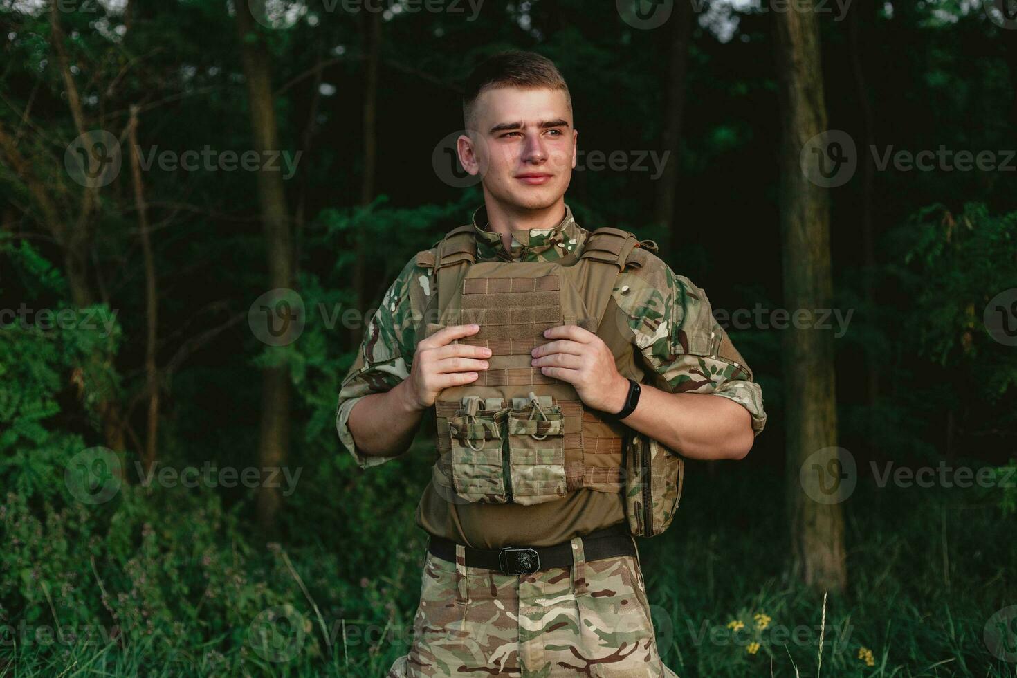 Soldier man standing against a field photo