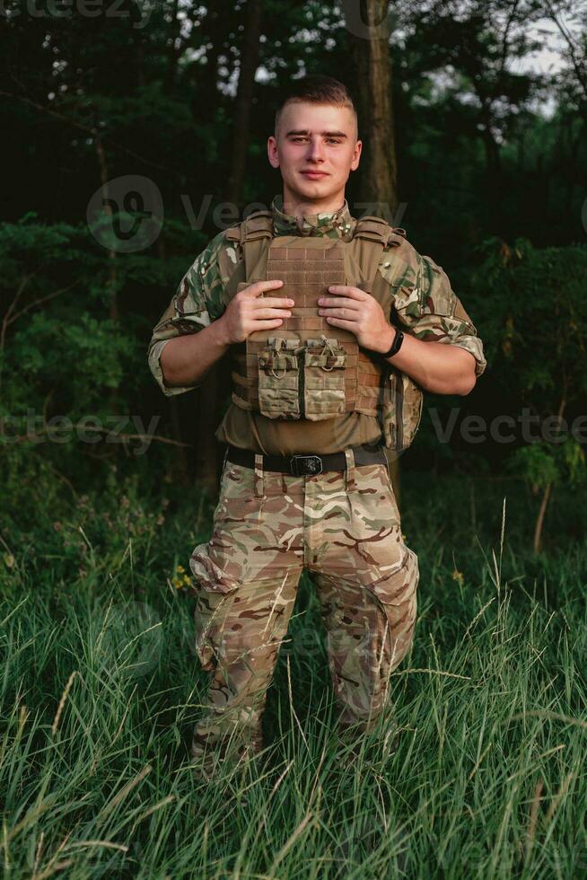 Soldier man standing against a field photo