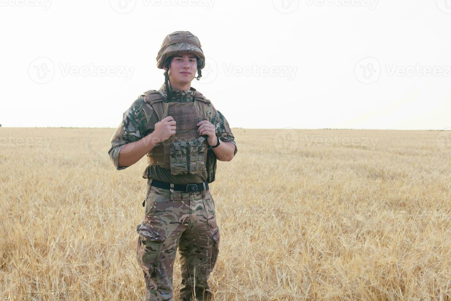 Soldier man standing against a field photo