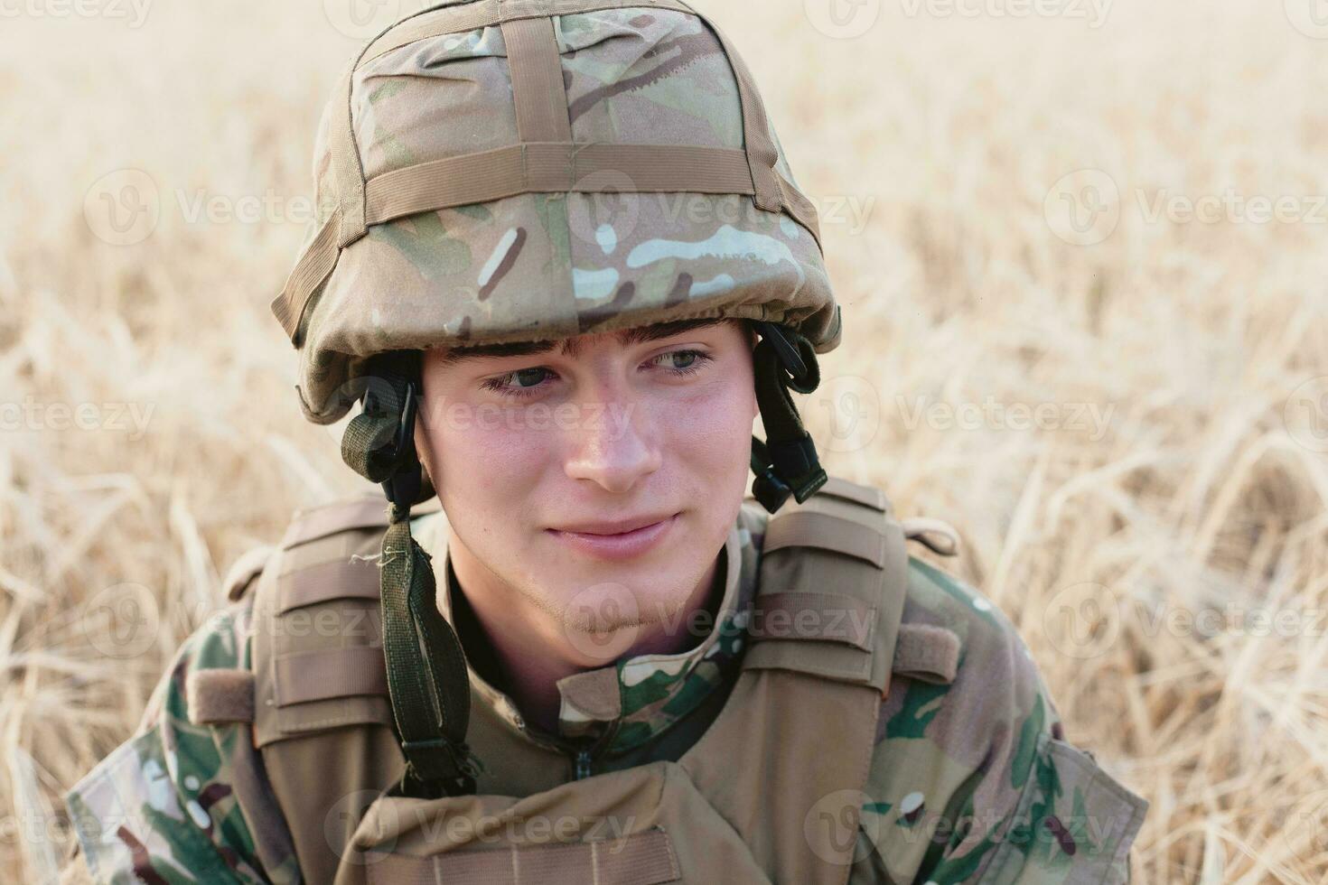 Soldier man standing against a field photo
