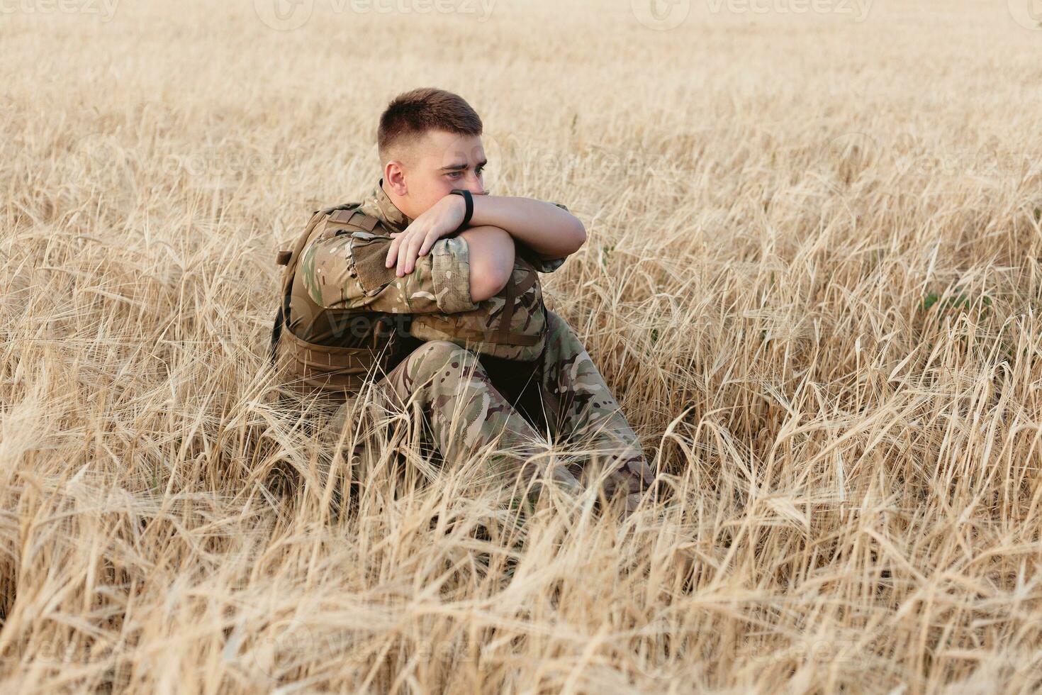 Soldier man standing against a field photo