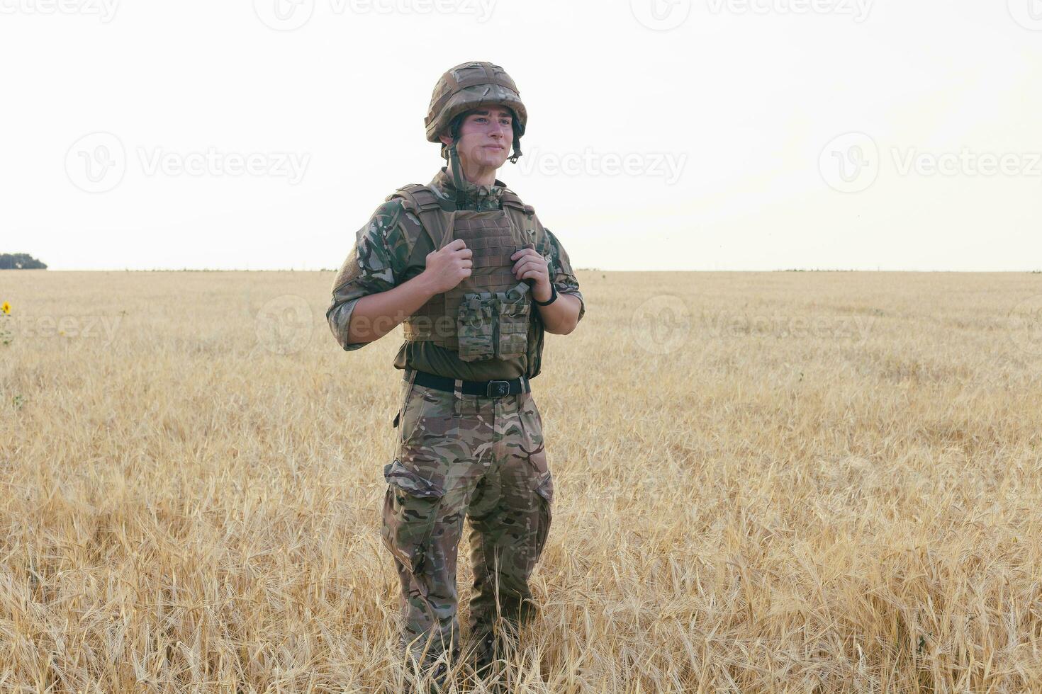 Soldier man standing against a field photo