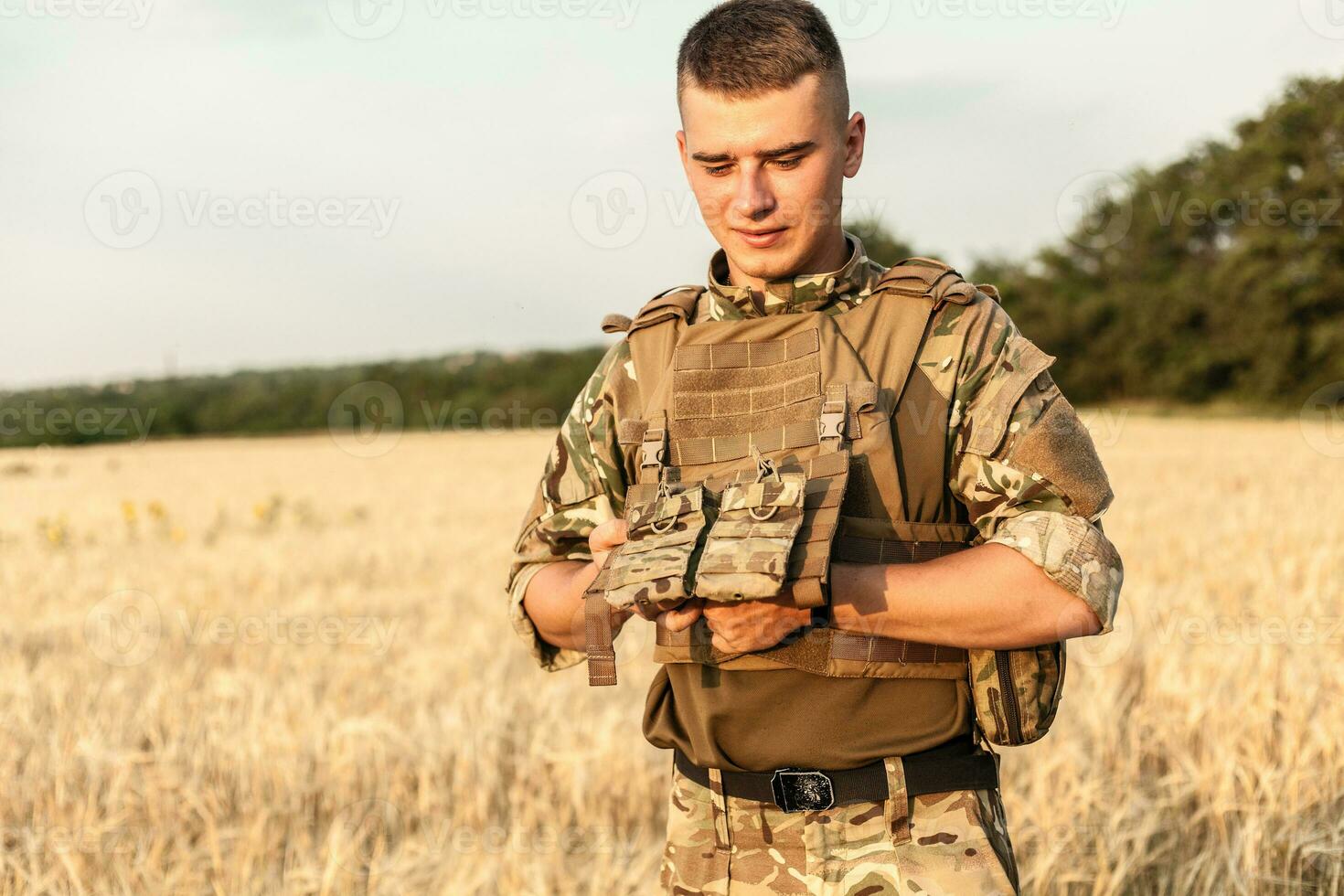 Soldier man standing against a field photo
