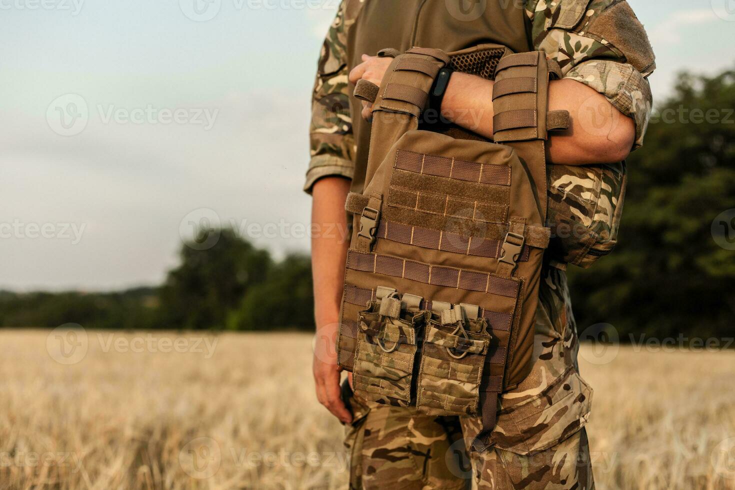 Soldier man standing against a field photo