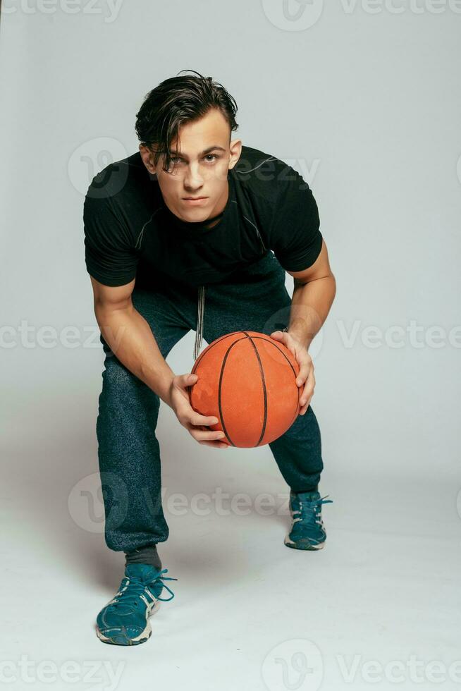 hermoso joven sonriente hombre que lleva un baloncesto pelota foto