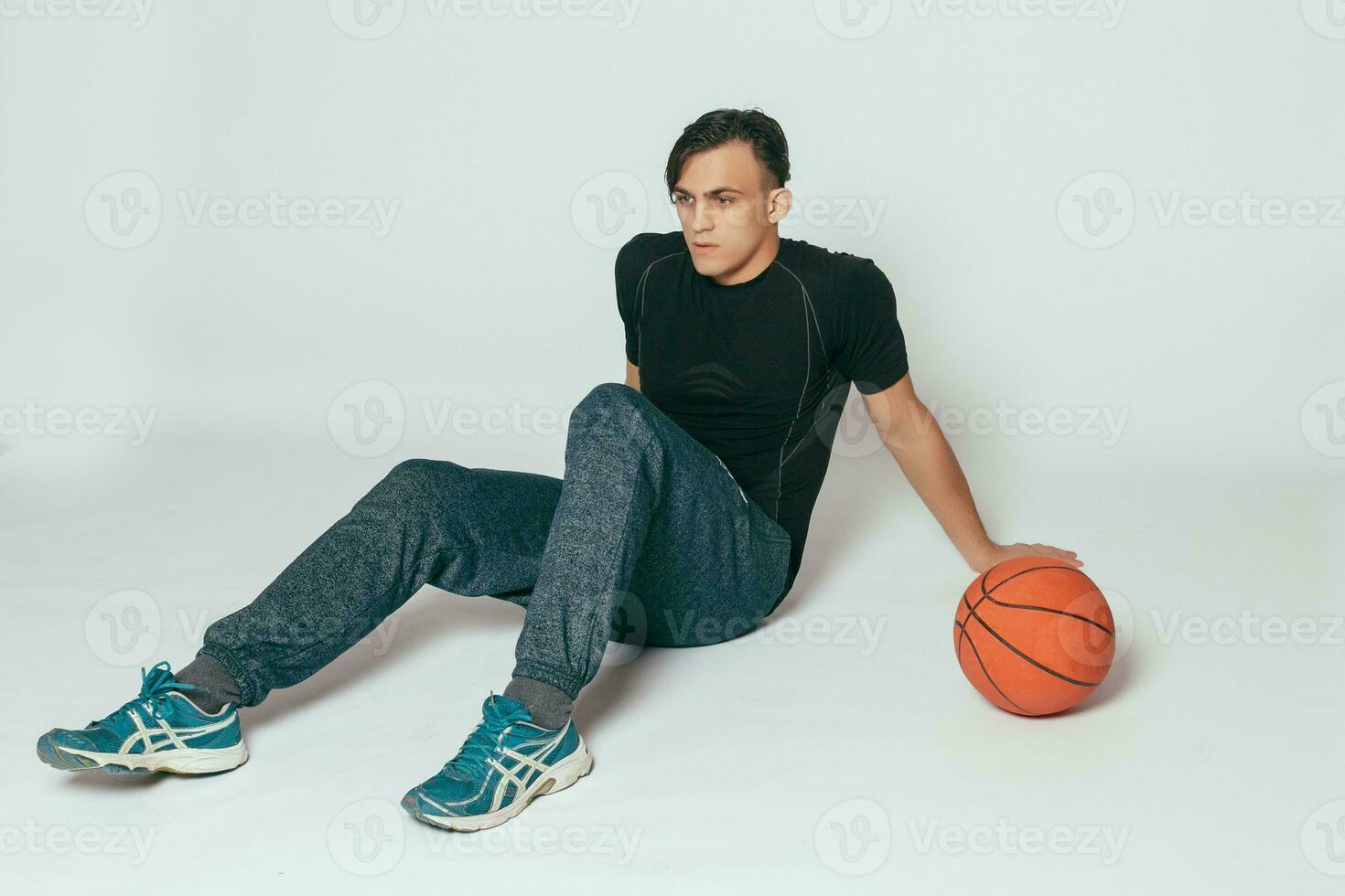 hermoso joven sonriente hombre que lleva un baloncesto pelota foto