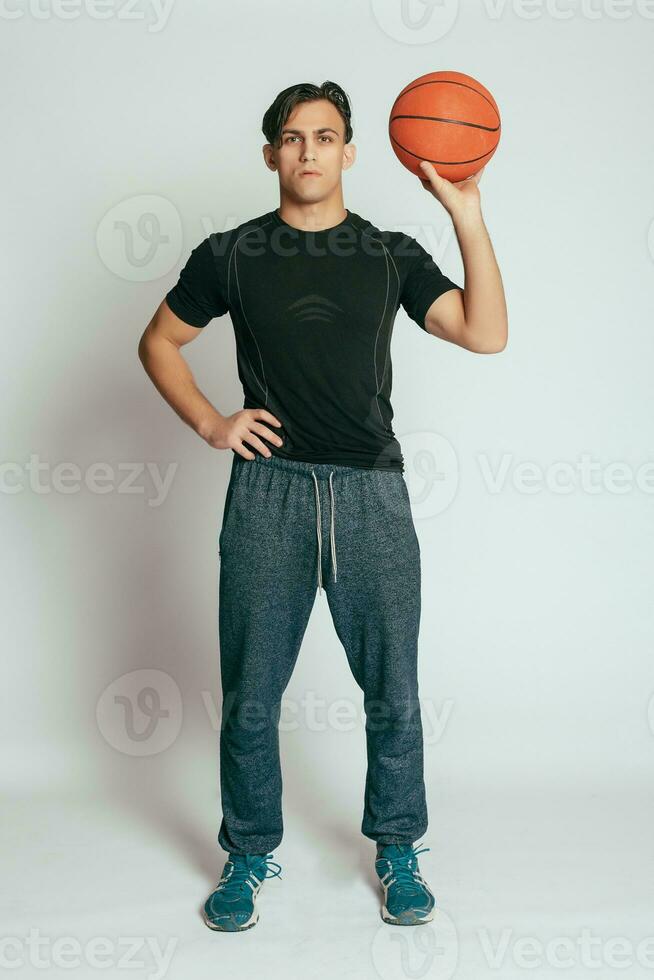 hermoso joven sonriente hombre que lleva un baloncesto pelota foto