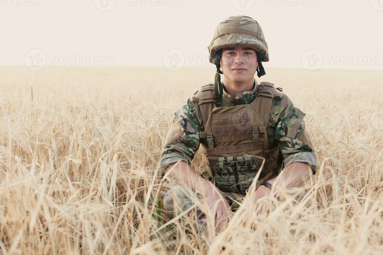 Soldier man standing against a field photo