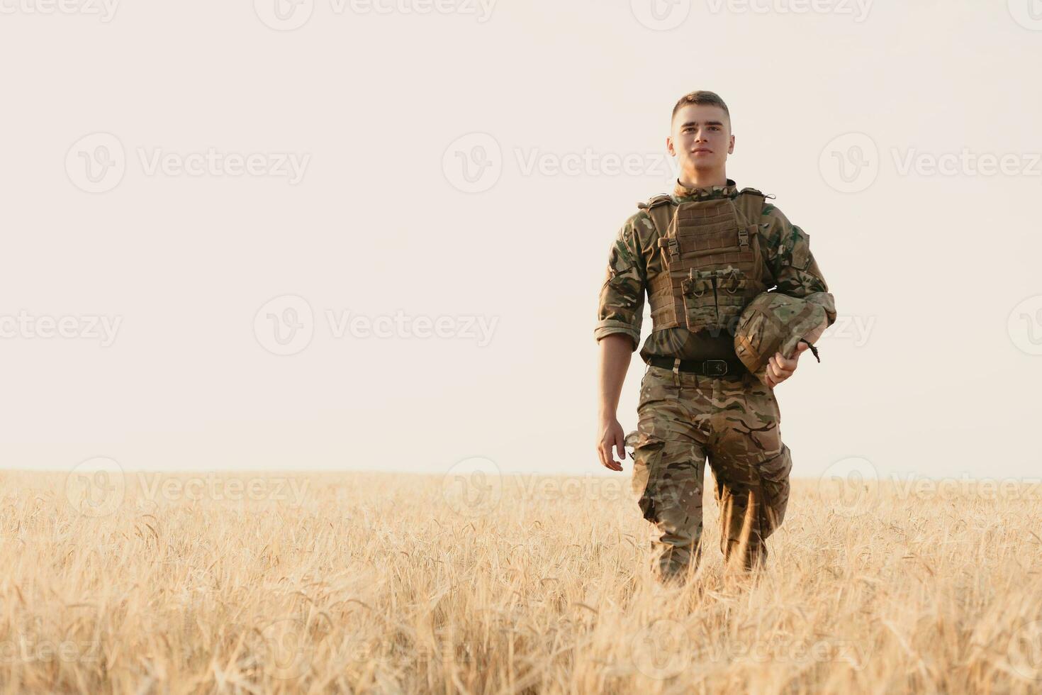 Soldier man standing against a field photo