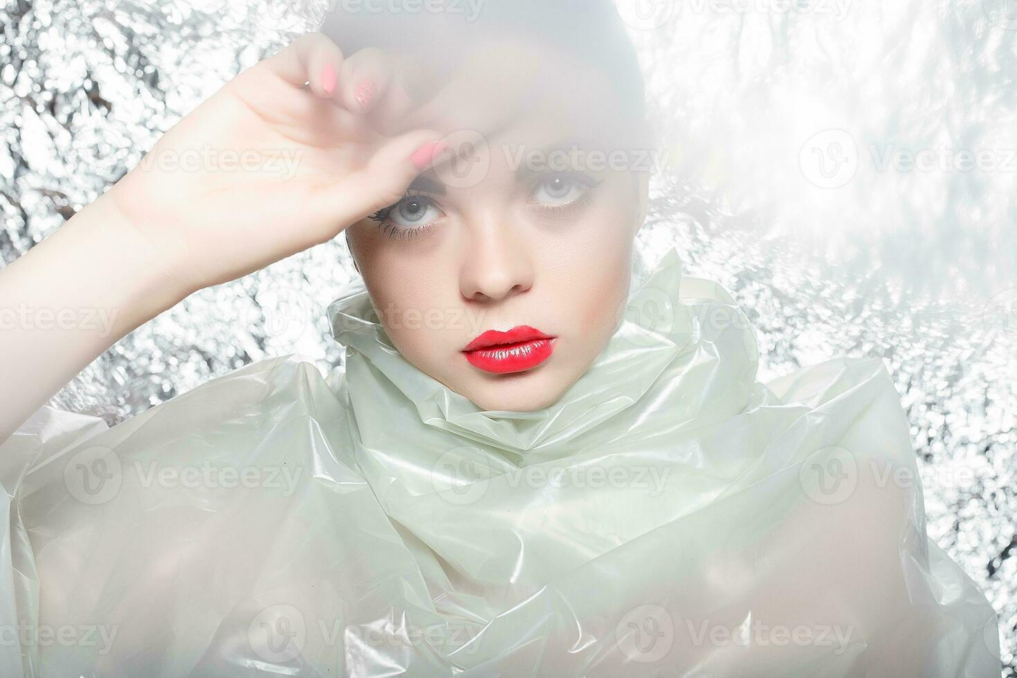 Young beautiful girl in a black dress on a silver background. photo