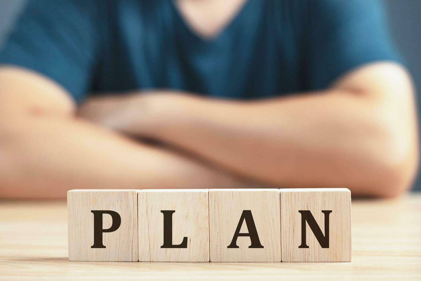 a businessman sit on table the wooden block on the plan to business finance and strategy. photo