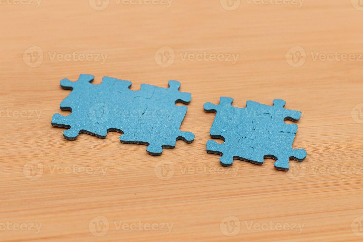 Top View of a Blue Puzzle Peaces Lie on the Wooden Table photo