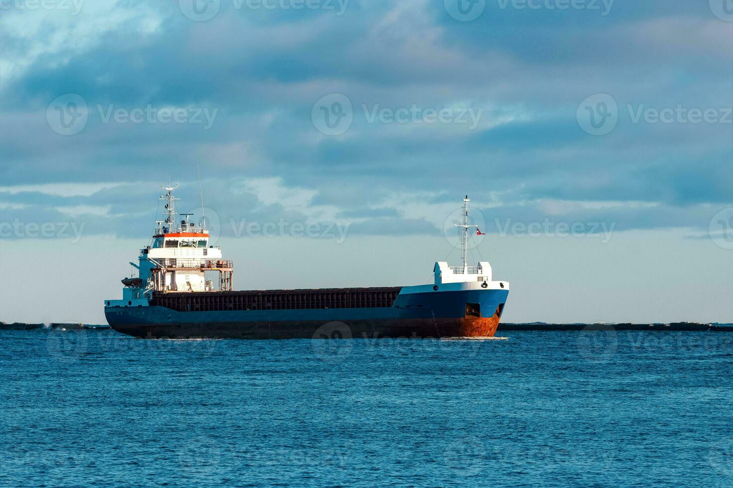 Blue bulk carrier sailing in still water photo