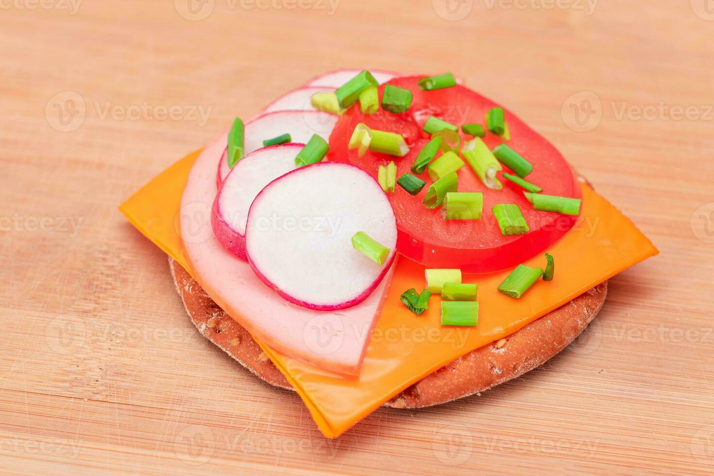 crujiente galleta emparedado con tomate, embutido, queso, verde cebollas y rábano en corte tablero. fácil desayuno. rápido y sano sándwiches pan crujiente con sabroso relleno. sano dietético bocadillo foto