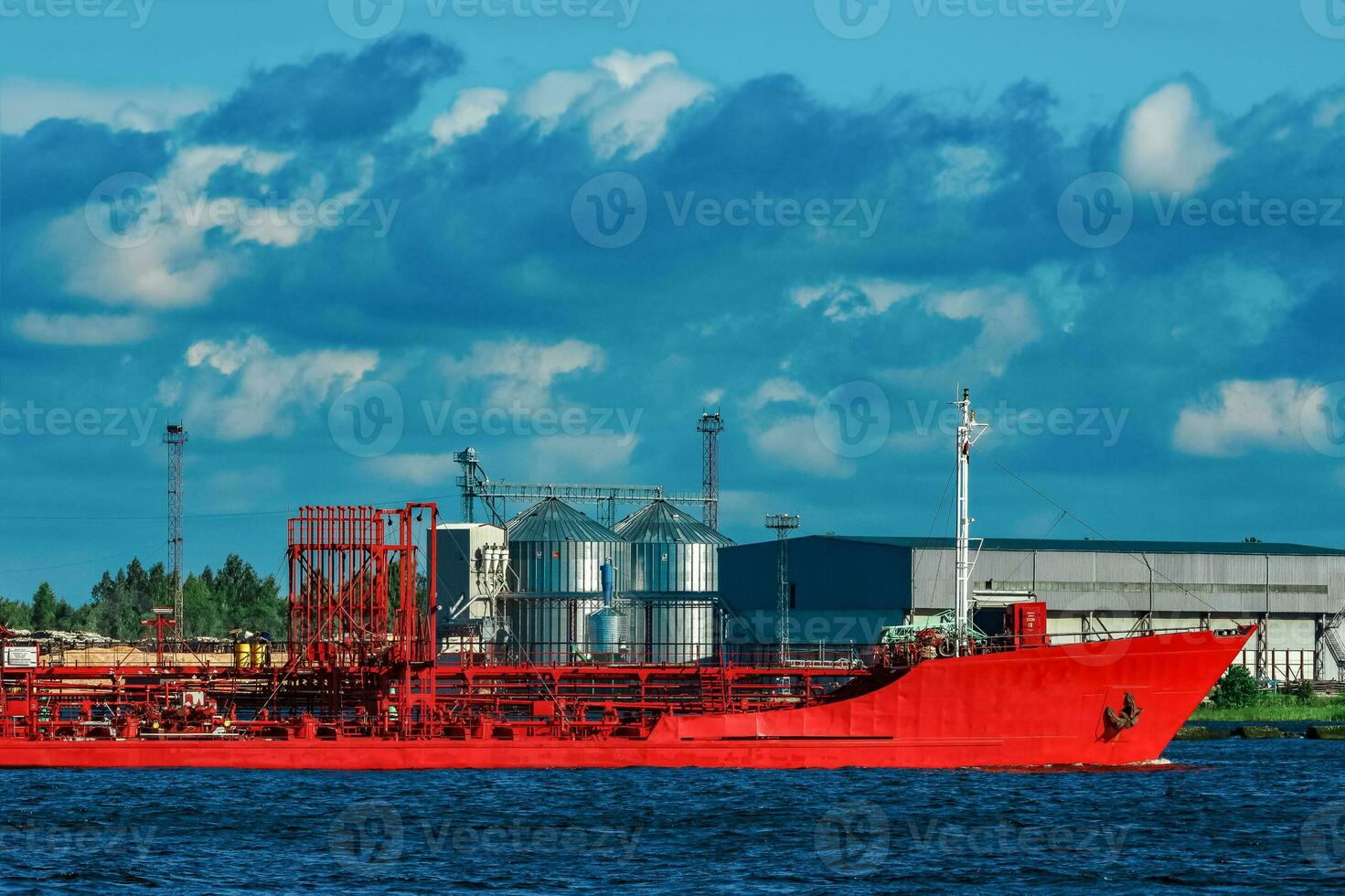 Red cargo tanker ship moving by the river photo