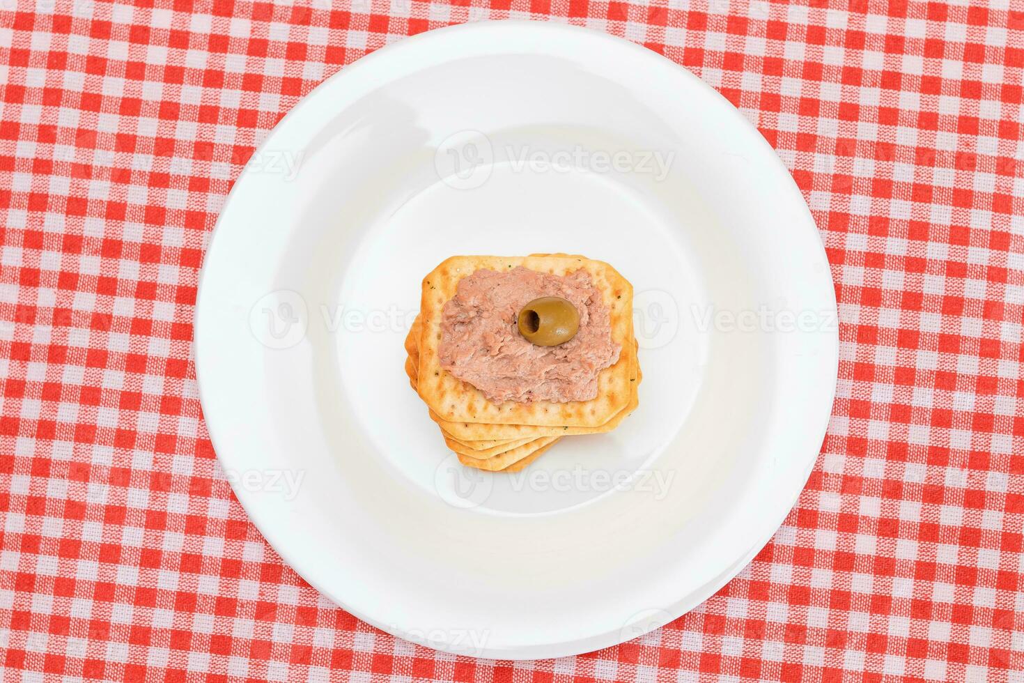 Crispy Salted Cracker with Liver Pate and Olives on White Plate. Easy Snack photo