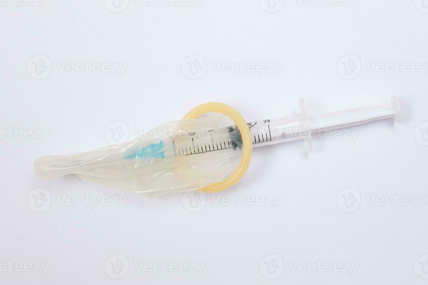 Save Vaccine and Anti Vaccination Concept Syringe in a Condom Lay on White Table. Mistrust of Vaccination. Natural Immunity. Skepticism About the Vaccine. Freedom and Human Rights photo