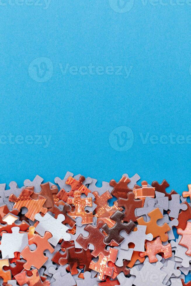 Mixed Peaces of a Colorful Jigsaw Puzzle Lie on the Blue Background With Copy Space Strategy and Solving Problem Concept photo