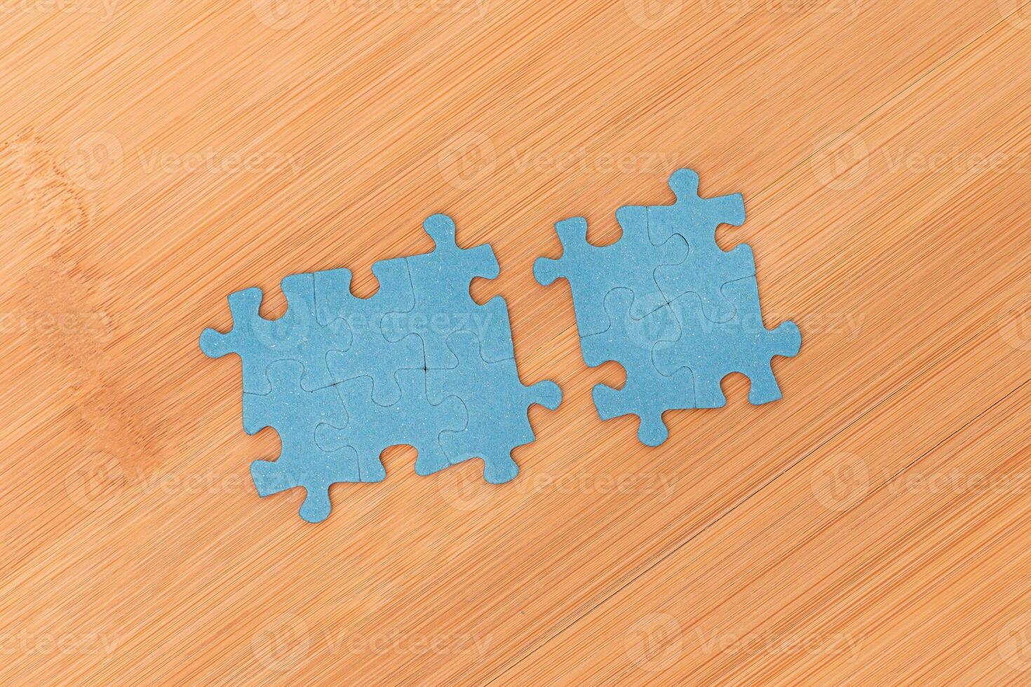 Top View of a Blue Puzzle Peaces Lie on the Wooden Table photo