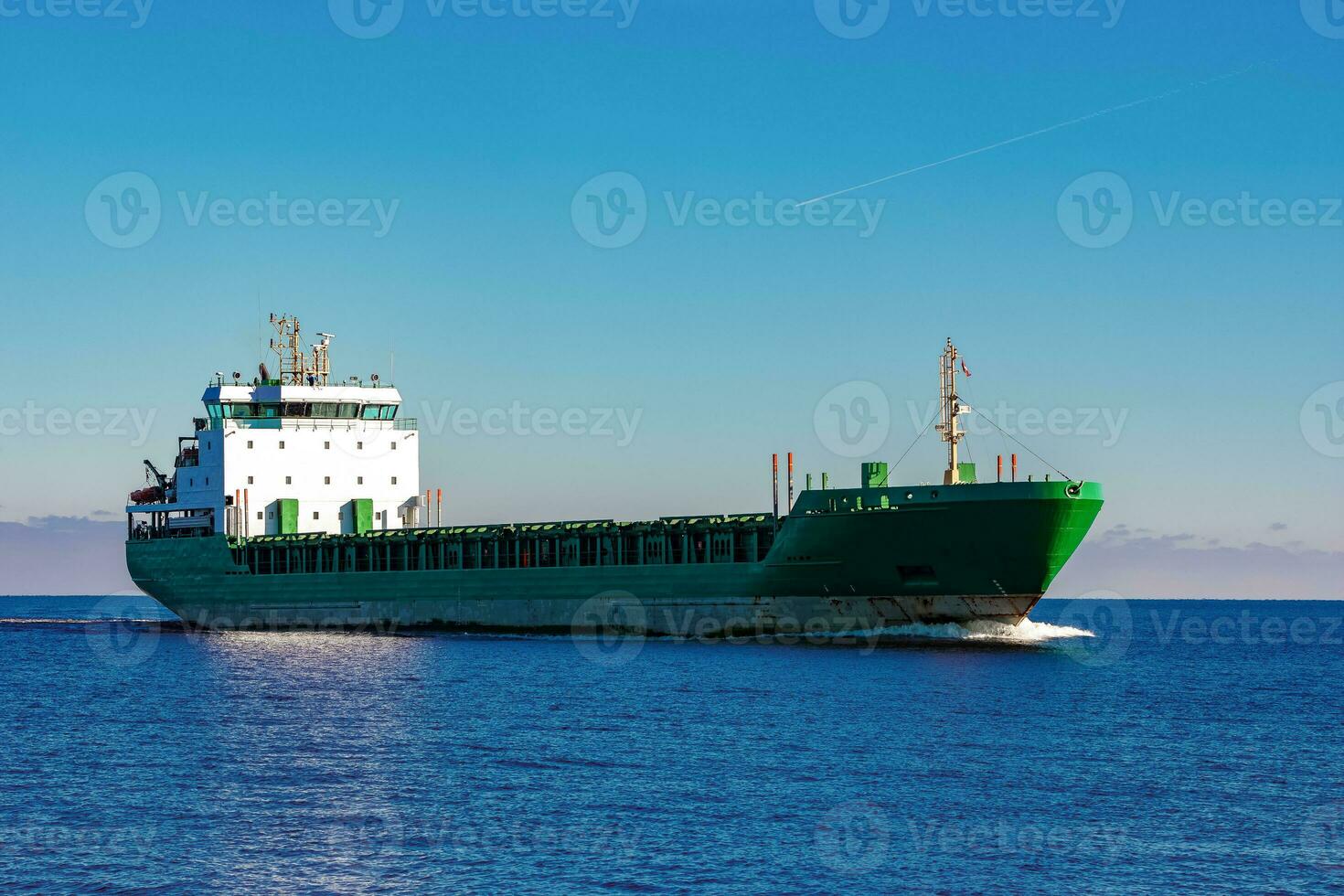 Green cargo ship moving in still water of Baltic sea photo