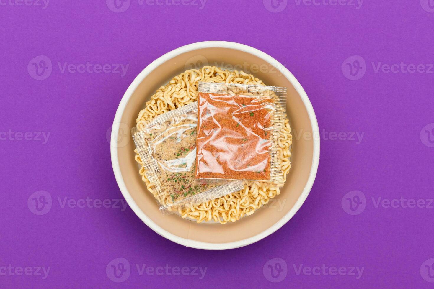 Opened Package with Uncooked Instant Noodles on Violet Background. Raw Pasta. Dry Asian Fast Food. Quick Lunch photo