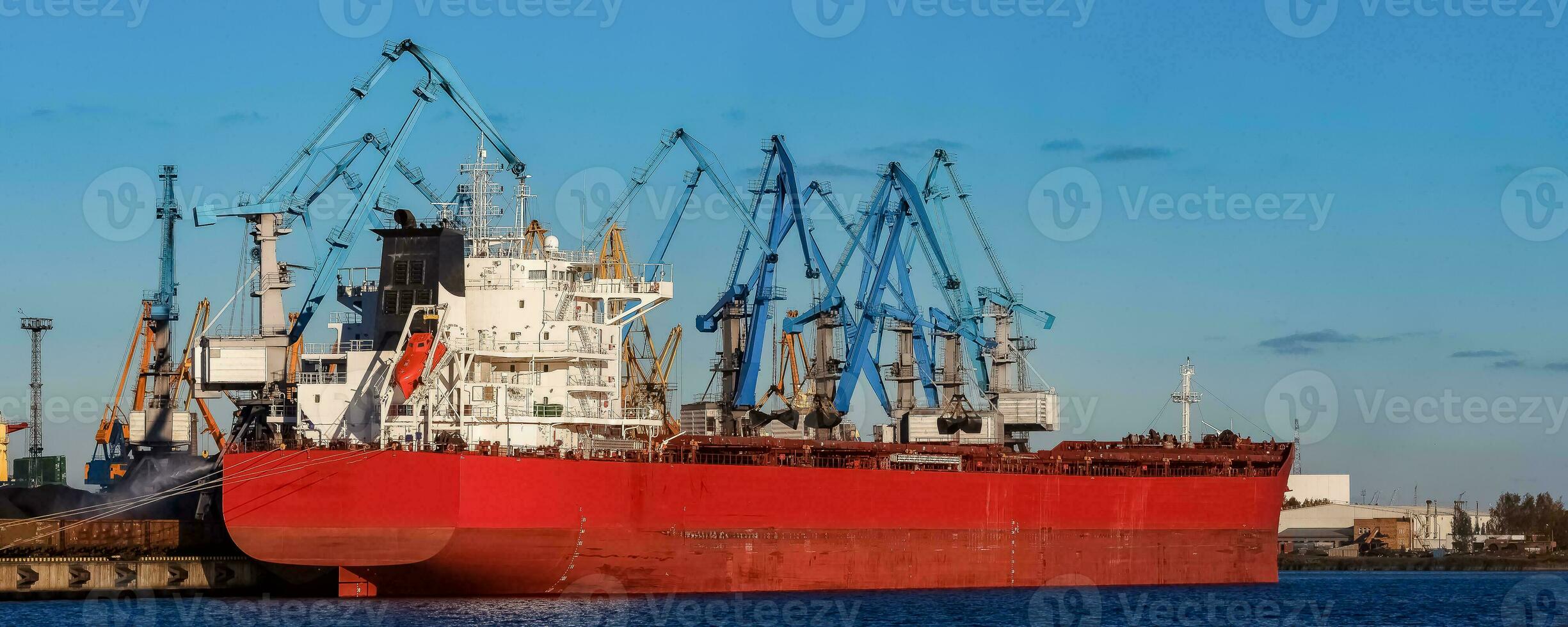 Red cargo ship loading in the port of Riga, Europe photo