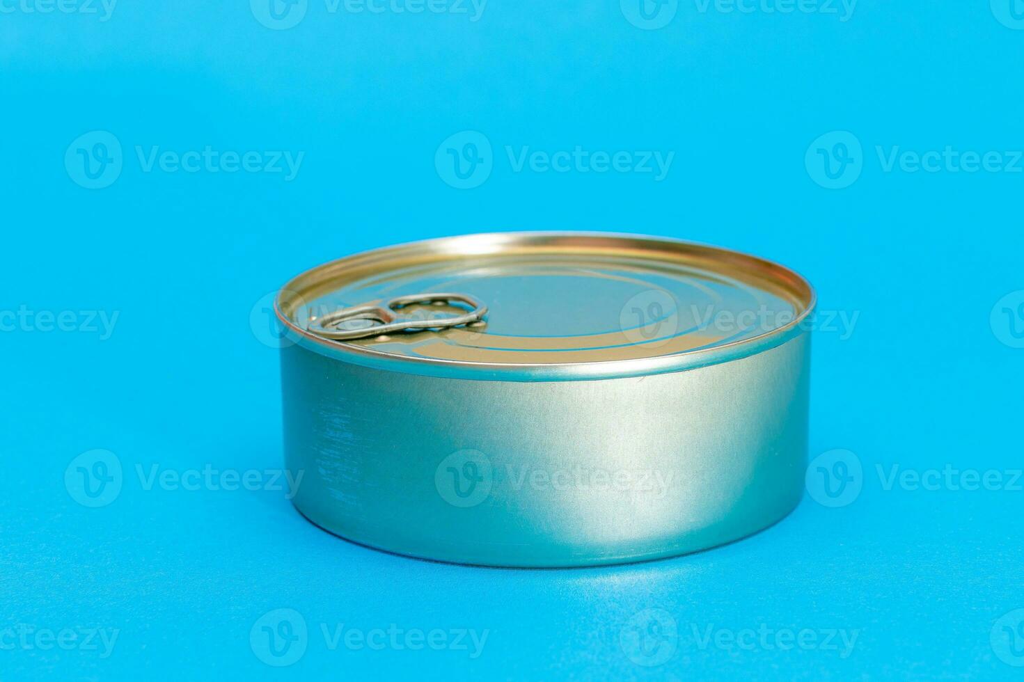 Unopened Tin Can with Blank Edge on Light Blue Background. Canned Food. Aluminum Can for Safe and Long Term Storage of Food. Steel Sealed Food Storage Container photo