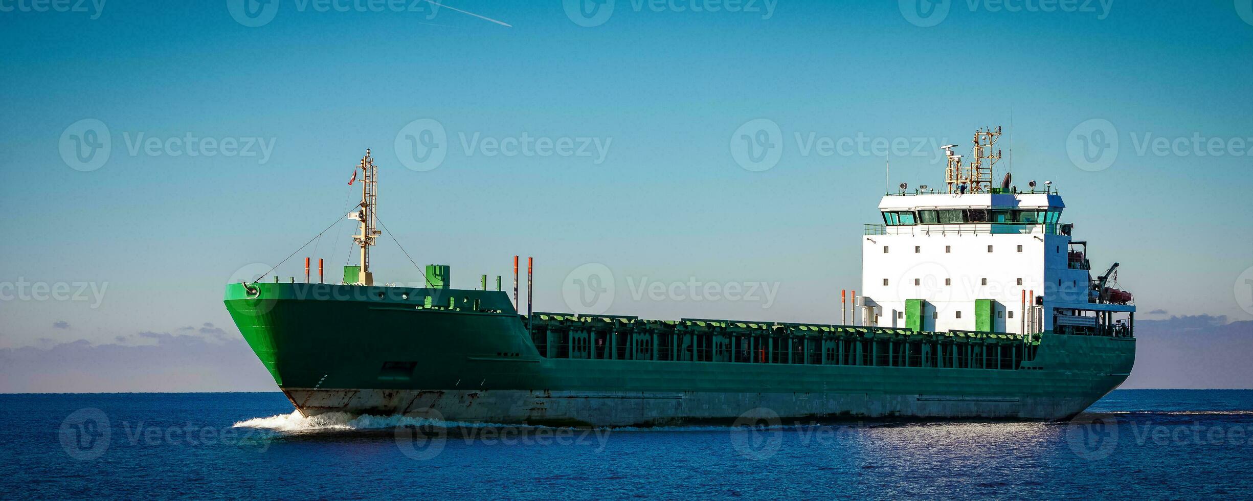 Green cargo ship moving in still water of Baltic sea photo