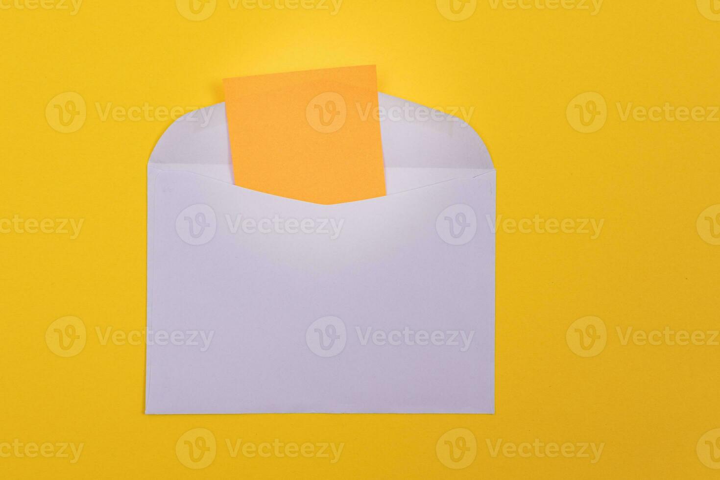 Violet Envelope with Blank Orange Sheet of Paper Inside, Lying on Yellow Background Mock Up with Copy Space. Receiving Mail or Notice, Sending Postcard Top View, Flat Lay photo