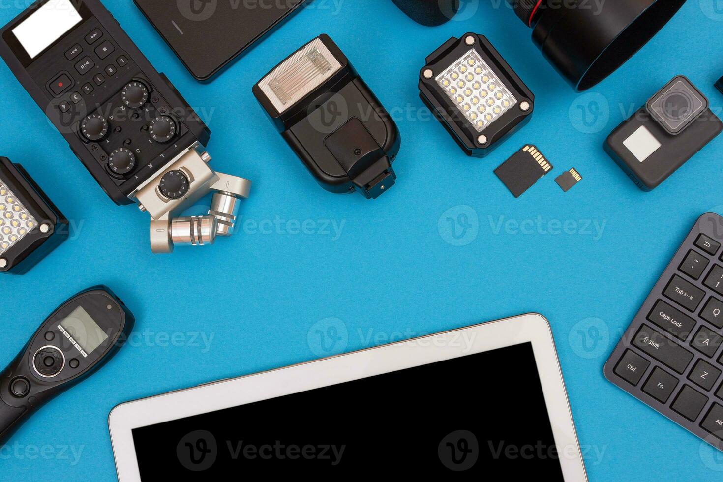 Top View of Photographer's, Videographer's or Video Blogger's Workplace. Digital Gadgets Lying on Blue Table Flat Lay photo