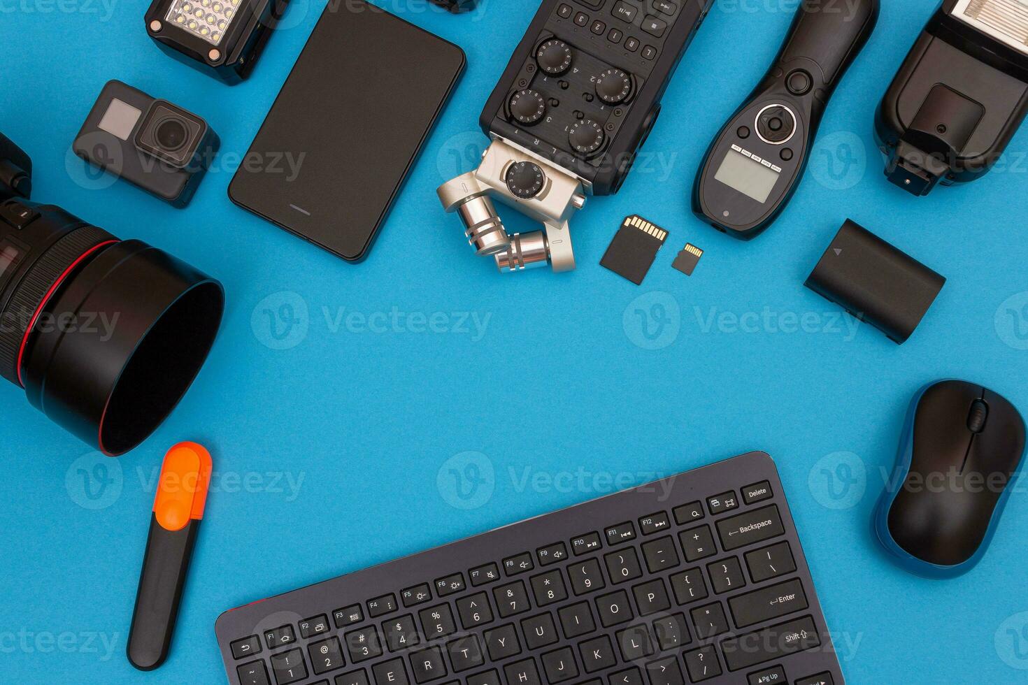 Top View of Photographer's, Videographer's or Video Blogger's Workplace. Digital Gadgets Lying on Blue Table Flat Lay photo