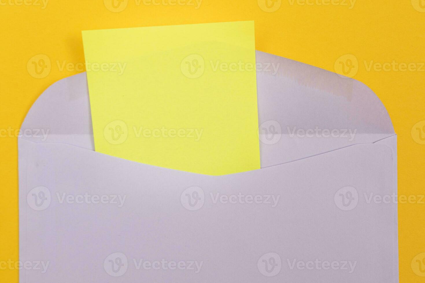 Violet Envelope with Blank Yellow Sheet of Paper Inside, Lying on Yellow Background Mock Up with Copy Space. Receiving Mail or Notice, Sending Postcard Top View, Flat Lay photo
