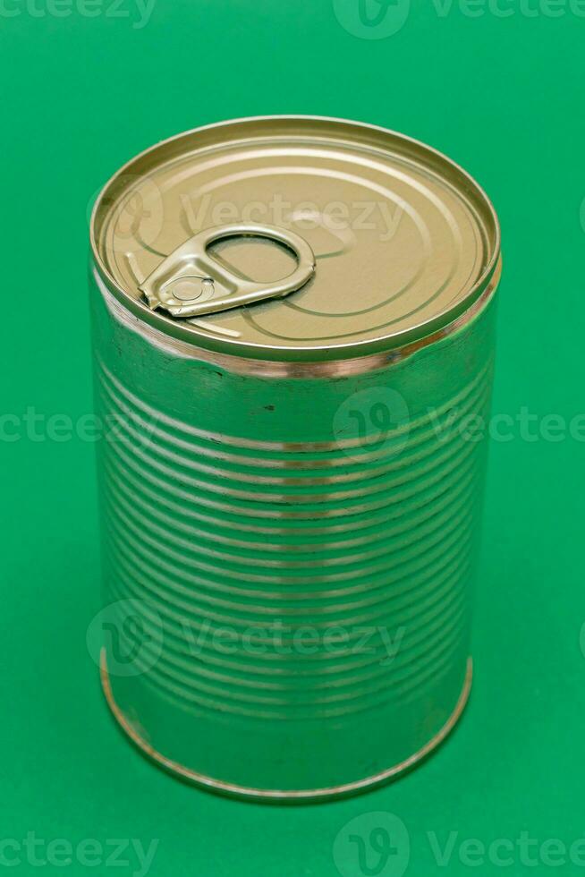 Unopened Tin Can with Blank Edge on Green Background. Canned Food. Aluminum Can for Safe and Long Term Storage of Food. Steel Sealed Food Storage Container photo