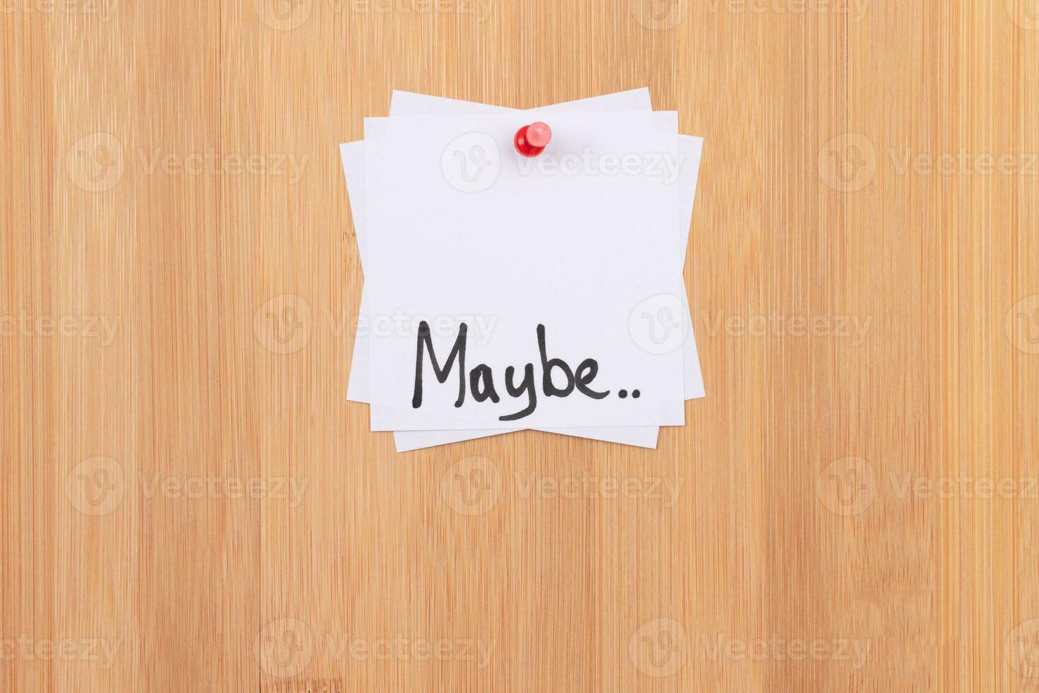 MAYBE.. White Sticky Notes with Written Word MAYBE, Pinned to the Wooden Message Board. To Do List Reminder in the Office. Memo Note at Work photo