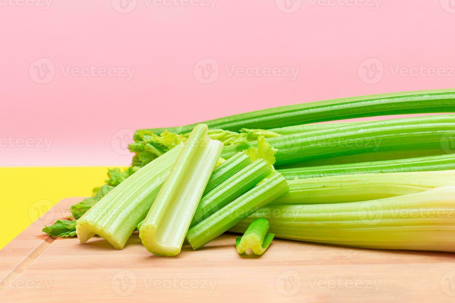 Fresh Celery Stem and Chopped Celery Sticks on Wooden Cutting Board. Vegan and Vegetarian Culture. Raw Food. Healthy Diet with Negative Calorie Content. Slimming Food photo