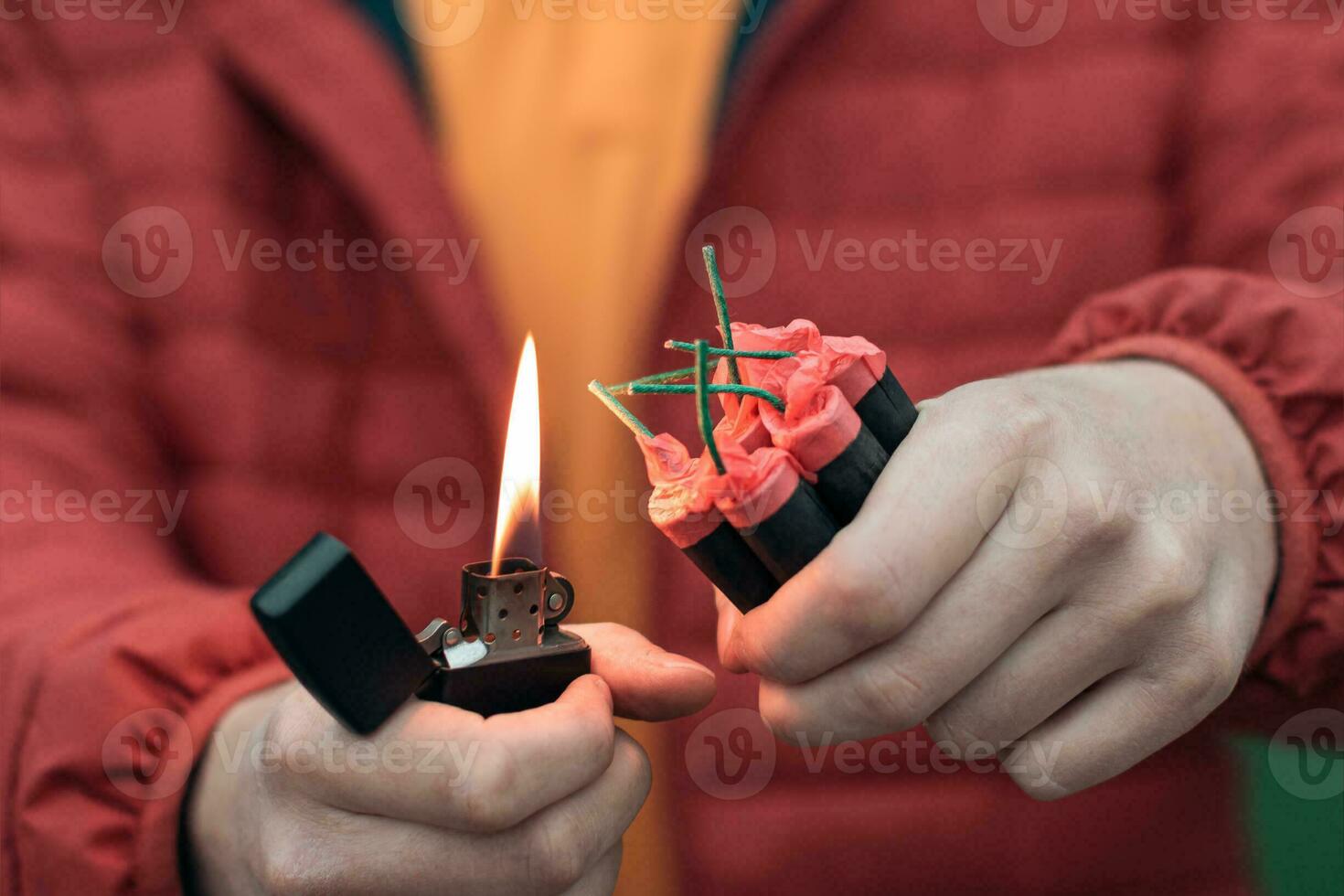 hombre en rojo secuestrado Encendiendo arriba varios petardos en su mano utilizando gasolina encendedor. chico consiguiendo Listo para nuevo año divertido con fuegos artificiales o pirotécnico productos foto