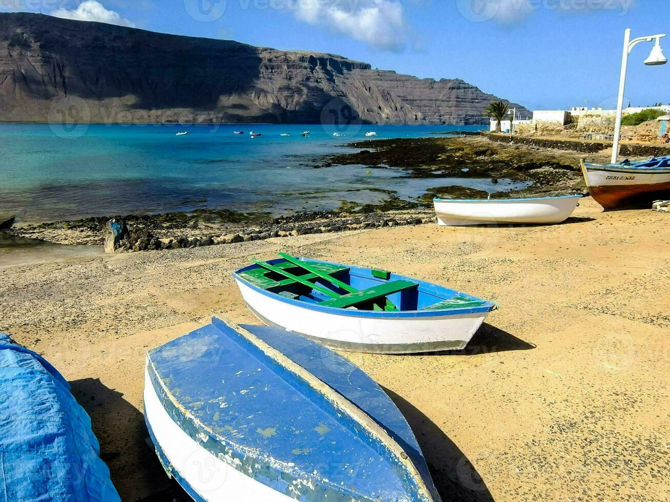 boats on the beach near a mountain range photo