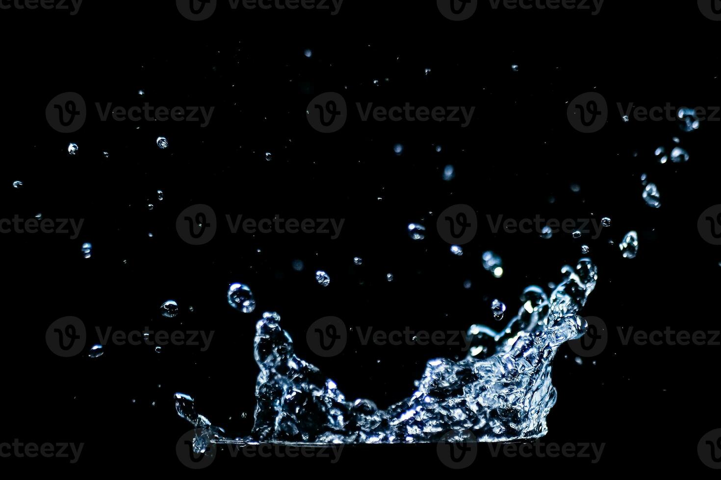 Splashing water on a black background. water droplets scattered on a black background photo