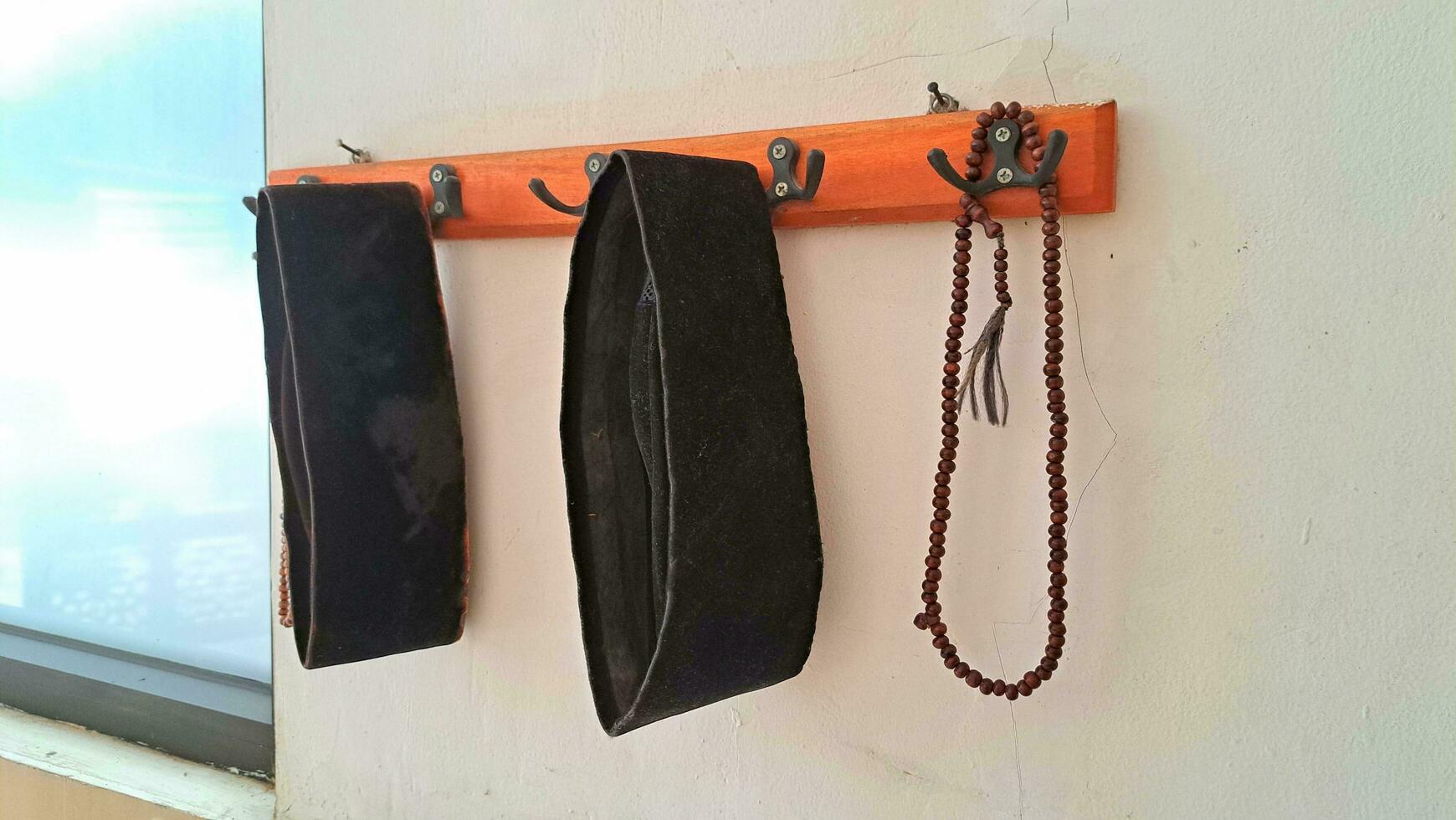 peci and prayer beads hanging on hangers photo