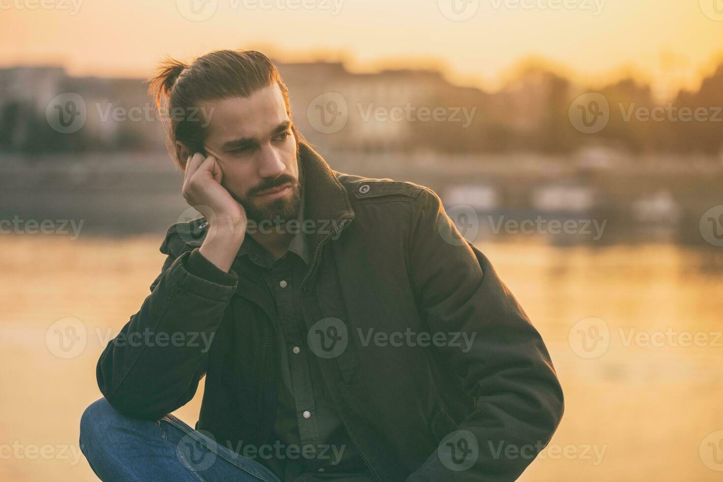 Deprimido moderno empresario sentado por el río.tonado imagen foto