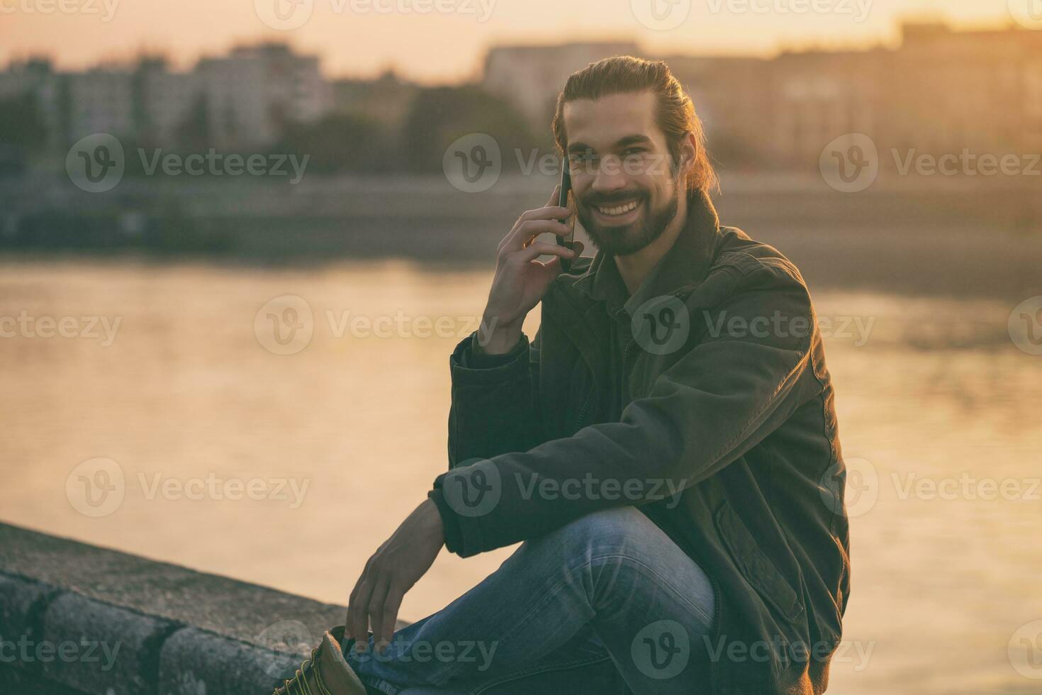 hermoso moderno empresario utilizando teléfono mientras sentado por el río.tonado imagen. foto