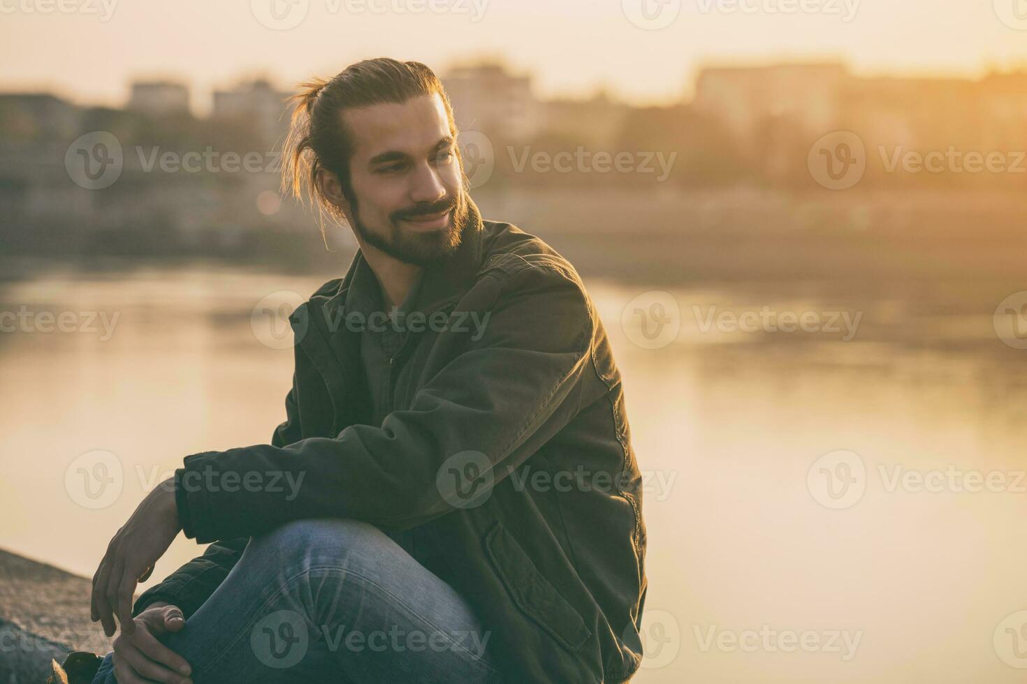 Handsome modern businessman enjoys resting by the river.Toned image photo