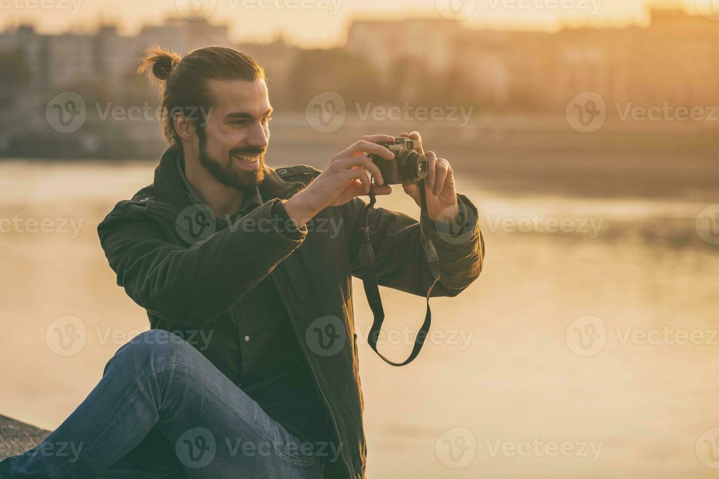 Handsome modern businessman enjoys photographing city.Toned image. photo
