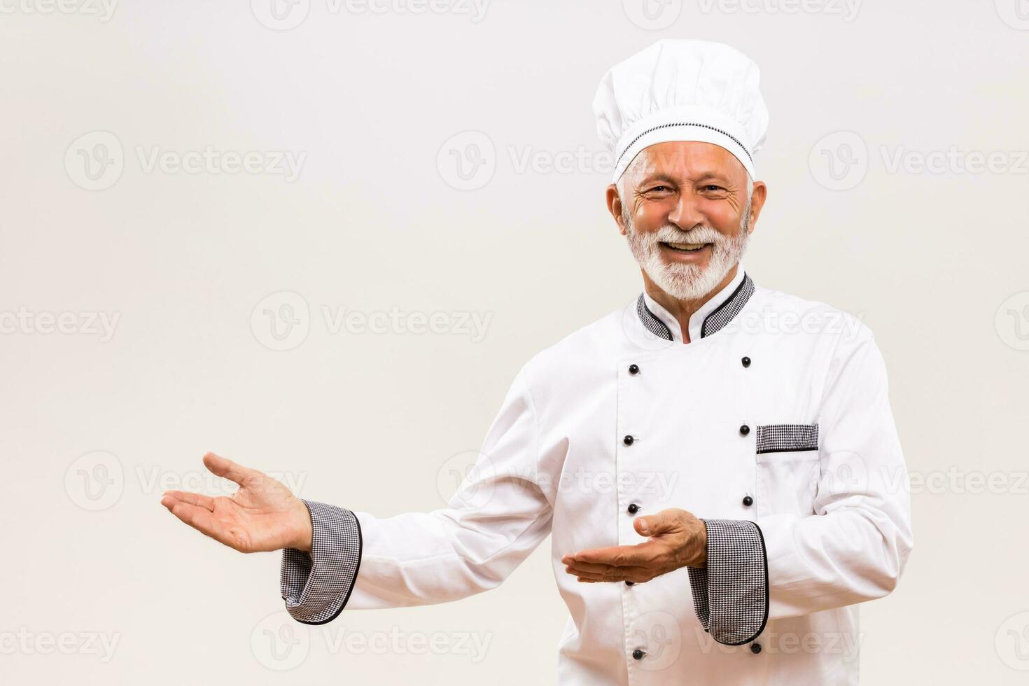 Portrait of senior chef showing welcome gesture. photo