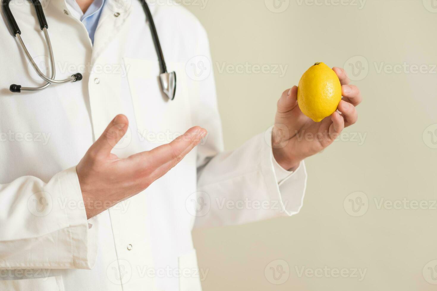 Image of male doctor showing lemon. photo