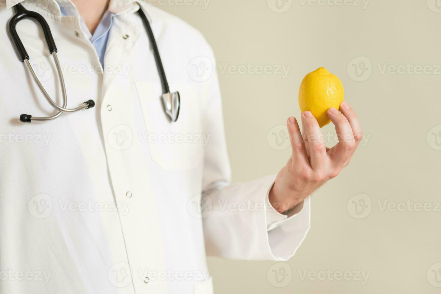 Image of male doctor holding lemon. photo
